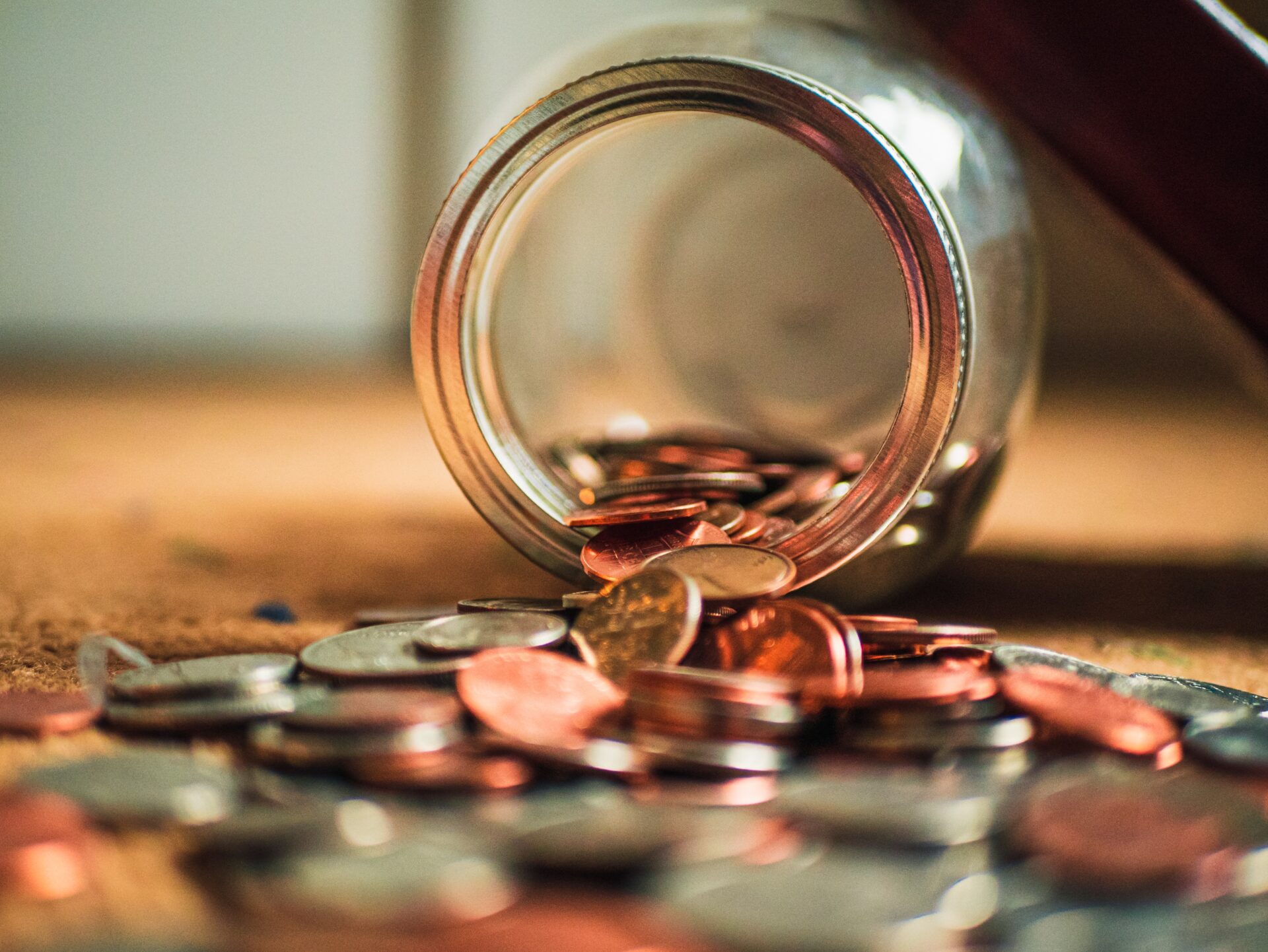 Glass mason jar with a few coins inside to illustrate poverty